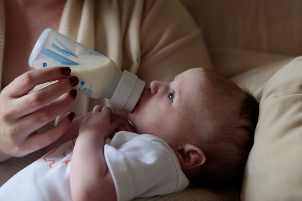 bébé qui boit un biberon de lait maternel
